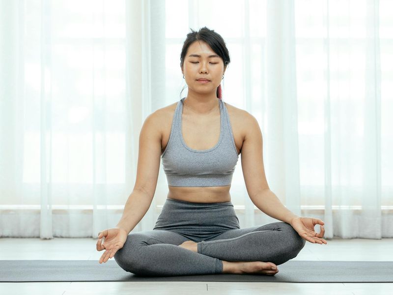 Spacious minimalist yoga studio with soft sunlight coming through windows.